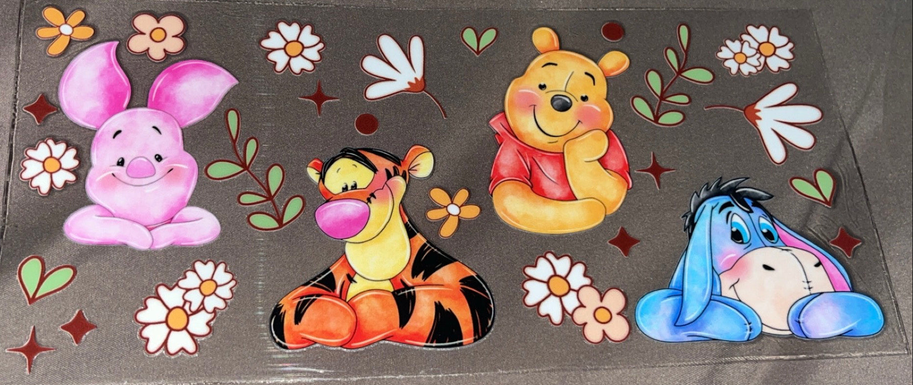 Whinne the Pooh,Tiger, Piglet, and Eeyore sitting with flowers